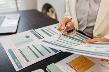 Ofiste bir sürü evrak işiyle uğraşan işadamı pazarlama verilerini kontrol ediyor ve bir çalışan da finans belgeleriyle çalışıyor, ofiste muhasebeci şirketinde çalışıyor.