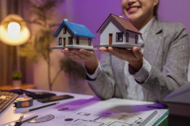 Tecrübeli bir kadın mühendis, özel ofisindeki bir ev modeline son bir çek veriyor. Planlara uyduğundan ve inşaatın bitiş tarihine yetiştiğinden emin olmak için.