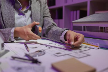 Güzel bir kadın mimar özel ofisinde çalışıyor çünkü kanunlara, mühendislere, ustabaşına ve müteahhitlere uygun olması için planların geliştirilmesine konsantre olması gerekiyor.