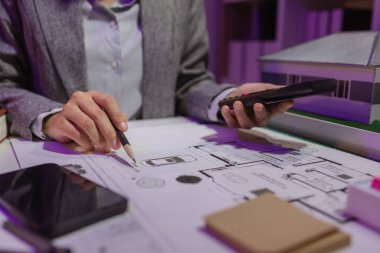 Güzel bir kadın mimar özel ofisinde çalışıyor çünkü kanunlara, mühendislere, ustabaşına ve müteahhitlere uygun olması için planların geliştirilmesine konsantre olması gerekiyor.