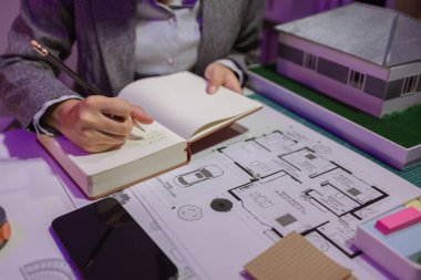 Güzel bir kadın mimar özel ofisinde çalışıyor çünkü kanunlara, mühendislere, ustabaşına ve müteahhitlere uygun olması için planların geliştirilmesine konsantre olması gerekiyor.