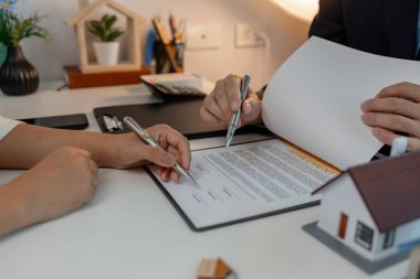 Personel kira sözleşmesi belgelerini alıcıya açıklıyor. Alıcı da kira sözleşmesini imzalıyor. Sahipliğin devri için personelle kontrat imzalıyor.