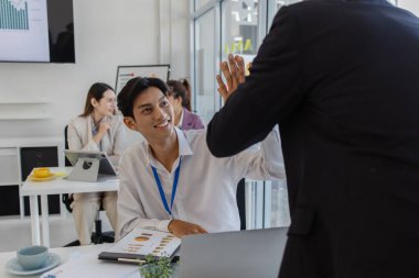 İş adamları beşlik çakıyor ya da yumruk tokuşturuyor ya da iyi yapılmış bir işten memnuniyetlerini ifade etmek için ellerini birleştiriyorlar. Çalışanlar başarılı bir projede mutluluklarını paylaşıyorlar.