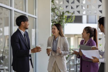 İş adamları şirkette yürürken konuşuyorlar, tüm planlama departmanı personeli toplantıya birlikte yürüyorlar, iş sahipleri ofise yürürken konuşuyorlar.