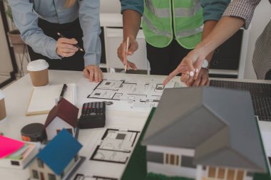 Mimarlar ve mühendisler gelecek binanın tasarımı ve yapısını ustabaşıyla tartışıyorlar. Detayları aynı sayfada anladıklarından emin olmak için. Beyin fırtınası, plan...