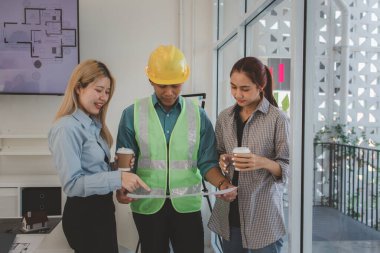Mimarlar ve mühendisler gelecek binanın tasarımı ve yapısını ustabaşıyla tartışıyorlar. Detayları aynı sayfada anladıklarından emin olmak için. Beyin fırtınası, plan...