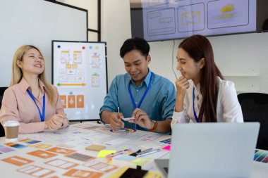 ux, ui, web ve mobil uygulama tasarımcıları, kullanıcılar için kolay ve keyifli hale getirmek için renk şemaları ve planlar da dahil olmak üzere tasarladıkları web sitesi veya uygulamanın görünüm ve hissini tartışıyor