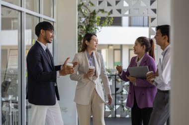 İş adamları şirkette yürürken konuşuyorlar, tüm planlama departmanı personeli toplantıya birlikte yürüyorlar, iş sahipleri ofise yürürken konuşuyorlar.