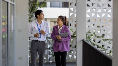 İş adamları şirkette yürürken konuşuyorlar, tüm planlama departmanı personeli toplantıya birlikte yürüyorlar, iş sahipleri ofise yürürken konuşuyorlar.