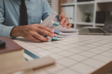 Ofisteki belgelerle bir işadamı ilgileniyor, bir muhasebeci belgeleri topluyor, bir pazarlama müdürü toplantı, finans, girişim, şirket bilgileri hazırlıyor