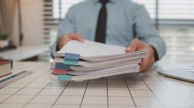 Ofisteki belgelerle bir işadamı ilgileniyor, bir muhasebeci belgeleri topluyor, bir pazarlama müdürü toplantı, finans, girişim, şirket bilgileri hazırlıyor