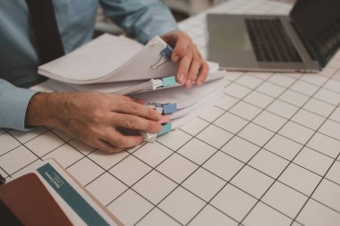 Ofisteki belgelerle bir işadamı ilgileniyor, bir muhasebeci belgeleri topluyor, bir pazarlama müdürü toplantı, finans, girişim, şirket bilgileri hazırlıyor