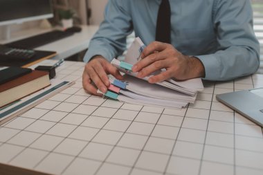 Ofisteki belgelerle bir işadamı ilgileniyor, bir muhasebeci belgeleri topluyor, bir pazarlama müdürü toplantı, finans, girişim, şirket bilgileri hazırlıyor