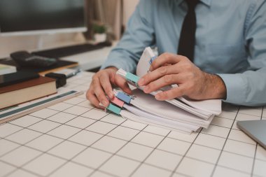 Ofisteki belgelerle bir işadamı ilgileniyor, bir muhasebeci belgeleri topluyor, bir pazarlama müdürü toplantı, finans, girişim, şirket bilgileri hazırlıyor