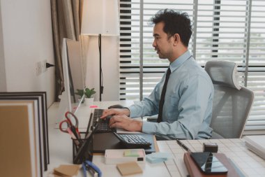 bir işadamı özel ofisinde oturuyor, bir girişimci özenle çalışıyor, baş muhasebeci yöneticilere bir toplantıda sunmak üzere belgeleri ve bütçe rakamlarını gözden geçiriyor