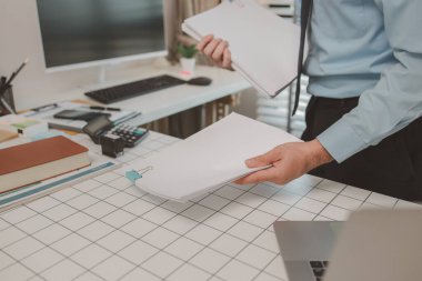 bir işadamı özel ofisinde oturuyor, bir girişimci özenle çalışıyor, baş muhasebeci yöneticilere bir toplantıda sunmak üzere belgeleri ve bütçe rakamlarını gözden geçiriyor