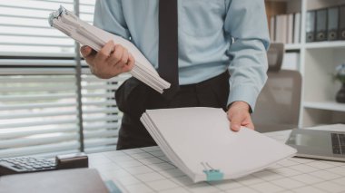 bir işadamı özel ofisinde oturuyor, bir girişimci özenle çalışıyor, baş muhasebeci yöneticilere bir toplantıda sunmak üzere belgeleri ve bütçe rakamlarını gözden geçiriyor