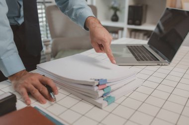 bir işadamı özel ofisinde oturuyor, bir girişimci özenle çalışıyor, baş muhasebeci yöneticilere bir toplantıda sunmak üzere belgeleri ve bütçe rakamlarını gözden geçiriyor