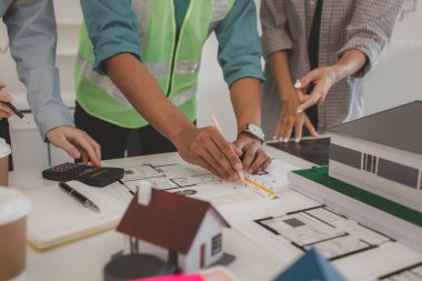 Mimarlar ve mühendisler gelecek binanın tasarımı ve yapısını ustabaşıyla tartışıyorlar. Detayları aynı sayfada anladıklarından emin olmak için. Beyin fırtınası, plan...