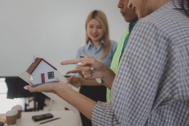 Mimar ve ekibi, bina modeli, mühendis ve takım çalışması ile planlardaki yapısal planların nasıl kontrol edileceği konusunda beyin fırtınası yapmak için inşaat yöneticisiyle görüşüyor.