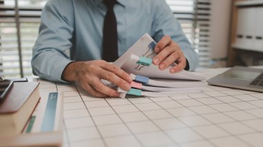 Ofisteki belgelerle bir işadamı ilgileniyor, bir muhasebeci belgeleri topluyor, bir pazarlama müdürü toplantı, finans, girişim, şirket bilgileri hazırlıyor