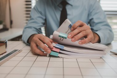 Ofisteki belgelerle bir işadamı ilgileniyor, bir muhasebeci belgeleri topluyor, bir pazarlama müdürü toplantı, finans, girişim, şirket bilgileri hazırlıyor