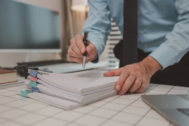 bir işadamı özel ofisinde oturuyor, bir girişimci özenle çalışıyor, baş muhasebeci yöneticilere bir toplantıda sunmak üzere belgeleri ve bütçe rakamlarını gözden geçiriyor