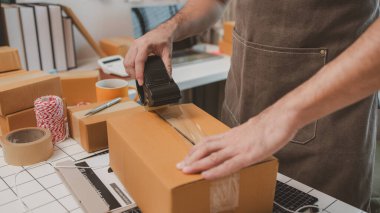 Çalışan, müşterilere nakliyeye hazırlanmak için ürünleri kutulara koyuyor, küçük bir online işletme sahibi müşterilere göndermeden önce doğruluk için kutucukları işaretliyor, paket,