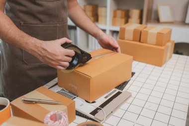 Girişimcinin kendi küçük internet şirketi vardır, işletme sahibi paketi müşteriye teslim etmeden önce kontrol eder, paket, ürün, küçük işletme, e-ticaret