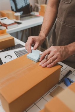 Çalışan, müşterilere nakliyeye hazırlanmak için ürünleri kutulara koyuyor, küçük bir online işletme sahibi müşterilere göndermeden önce doğruluk için kutucukları işaretliyor, paket,