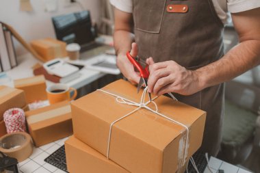 Çalışan, müşterilere nakliyeye hazırlanmak için ürünleri kutulara koyuyor, küçük bir online işletme sahibi müşterilere göndermeden önce doğruluk için kutucukları işaretliyor, paket,