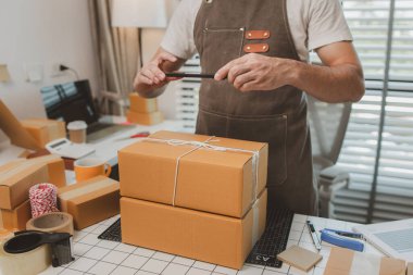 Paketleme odasındaki kutuları kontrol ediyor, küçük bir işletme sahibi kutuları müşterilere, ürünlere, e-ticarete, çevrimiçi satış ve ihracat şirketlerindeki girişimcilere göndermek için hazırlıyor.