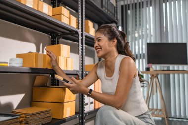 Depo çalışanı depoda paketlenmiş kutuları işaretliyor. Çevrimiçi iş yapan küçük bir işletme sahibi müşterilere, paketlere, e-ticarete göndermek için paket paketliyor.,