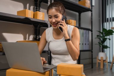 Depo çalışanı depoda paketlenmiş kutuları işaretliyor. Çevrimiçi iş yapan küçük bir işletme sahibi müşterilere, paketlere, e-ticarete göndermek için paket paketliyor.,