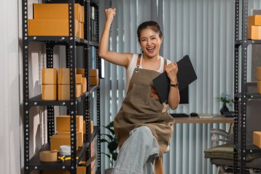 Küçük bir internet işletmesi sahibi, işi başarılı olduğu için kendini çok mutlu hissediyor. Girişimci, depo, paket, küçük işletme, neşe içinde olduğu süre zarfında neşesini gösteriyor.