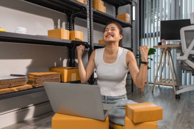 Küçük bir internet işletmesi sahibi, işi başarılı olduğu için kendini çok mutlu hissediyor. Girişimci, depo, paket, küçük işletme, neşe içinde olduğu süre zarfında neşesini gösteriyor.