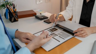 Bir muhasebe firmasının insan kaynakları müdürü pazarlama, özgeçmiş, işe alım, insan kaynakları, iş görüşmesi için bir adayla görüşüyor. Özgeçmişini ofisteki İnsan Kaynakları bölümüne sunuyor.