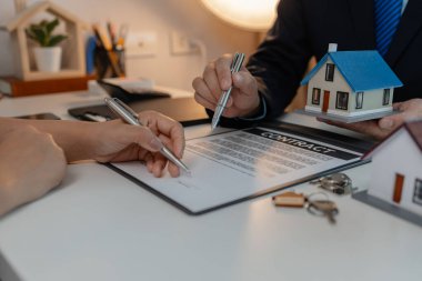 Personel kira sözleşmesi belgelerini alıcıya açıklıyor. Alıcı da kira sözleşmesini imzalıyor. Sahipliğin devri için personelle kontrat imzalıyor.