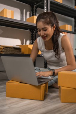 Depo çalışanı depoda paketlenmiş kutuları işaretliyor. Çevrimiçi iş yapan küçük bir işletme sahibi müşterilere, paketlere, e-ticarete göndermek için paket paketliyor.,