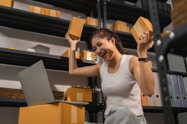 Küçük bir internet işletmesi sahibi, işi başarılı olduğu için kendini çok mutlu hissediyor. Girişimci, depo, paket, küçük işletme, neşe içinde olduğu süre zarfında neşesini gösteriyor.