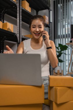 Paketleyici, bir müşteriye teslim edilmeden önce paketin durumunu kontrol eder, küçük bir işletme sahibi bir depodaki kutuları inceler, raflarla dolu bir depo ve paket