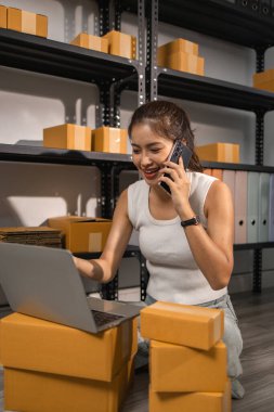 Depo çalışanı depoda paketlenmiş kutuları işaretliyor. Çevrimiçi iş yapan küçük bir işletme sahibi müşterilere, paketlere, e-ticarete göndermek için paket paketliyor.,