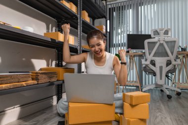 Küçük bir internet işletmesi sahibi, işi başarılı olduğu için kendini çok mutlu hissediyor. Girişimci, depo, paket, küçük işletme, neşe içinde olduğu süre zarfında neşesini gösteriyor.