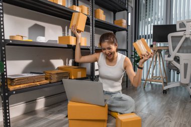 Küçük bir internet işletmesi sahibi, işi başarılı olduğu için kendini çok mutlu hissediyor. Girişimci, depo, paket, küçük işletme, neşe içinde olduğu süre zarfında neşesini gösteriyor.