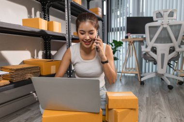 Depodaki paket kutularıyla çalışan bir çalışan depodaki paket kutularının sayısını kontrol eder. Nakliye işindeki bir girişimci depoyu teftiş etmek için gelir.