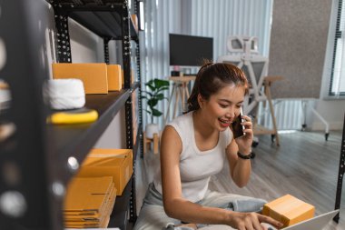 Depodaki paket kutularıyla çalışan bir çalışan depodaki paket kutularının sayısını kontrol eder. Nakliye işindeki bir girişimci depoyu teftiş etmek için gelir.