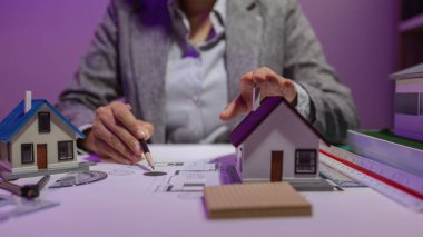 Tecrübeli bir kadın mühendis, özel ofisindeki bir ev modeline son bir çek veriyor. Planlara uyduğundan ve inşaatın bitiş tarihine yetiştiğinden emin olmak için.