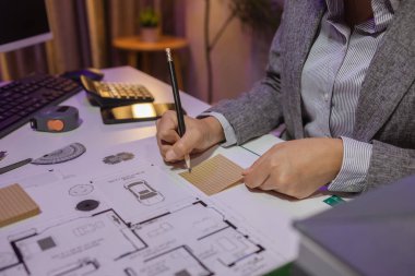 Güzel bir kadın mimar özel ofisinde çalışıyor çünkü kanunlara, mühendislere, ustabaşına ve müteahhitlere uygun olması için planların geliştirilmesine konsantre olması gerekiyor.