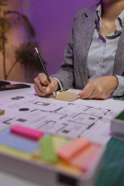 Güzel bir kadın mimar özel ofisinde çalışıyor çünkü kanunlara, mühendislere, ustabaşına ve müteahhitlere uygun olması için planların geliştirilmesine konsantre olması gerekiyor.