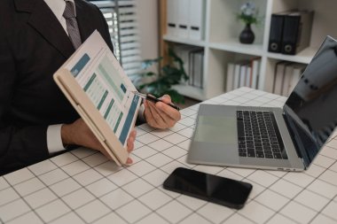 Bir işadamı daha iyi anlamak için bir belgede bilgi araştırması yapmaktadır, bir bölüm başkanı astları, muhasebecisi, ofisi tarafından gönderilen istatistiksel belgeleri gözden geçirir.